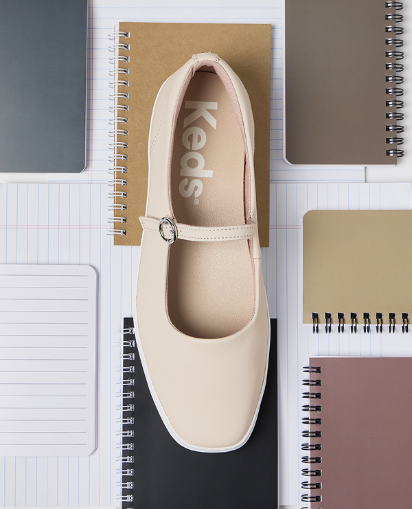 A collage-style arrangement of neutral-colored notebooks and lined paper featuring an overhead view of the Square Toe Mary Jane Leather in peony pink at the center.