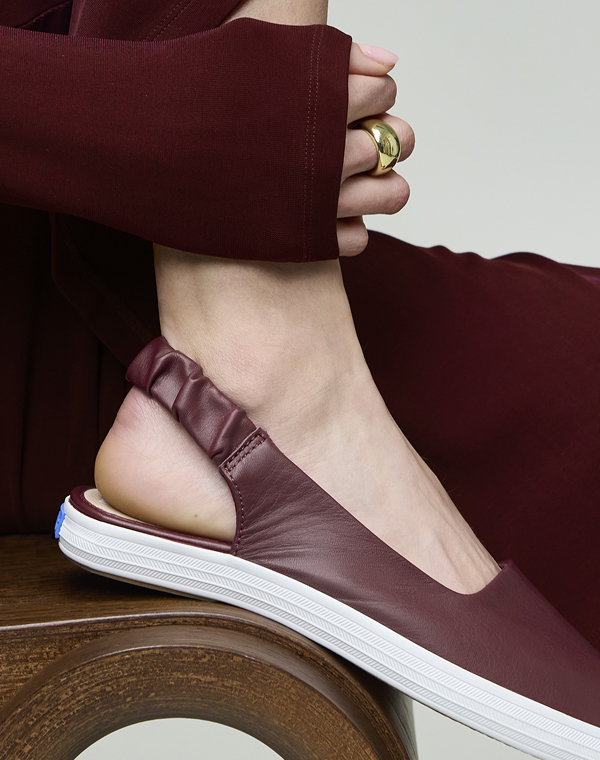 A close-up of the Point Slingback Leather in red on foot paired styled with a maroon outfit.