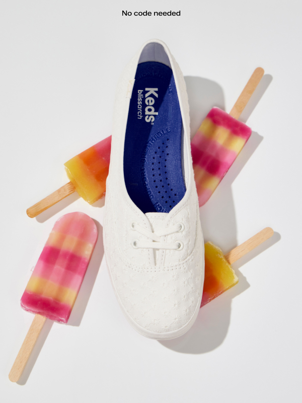 An overhead view of the Mini Daisy Eyelet Slip-On in snow white surrounded by four sunset-striped popsicles.