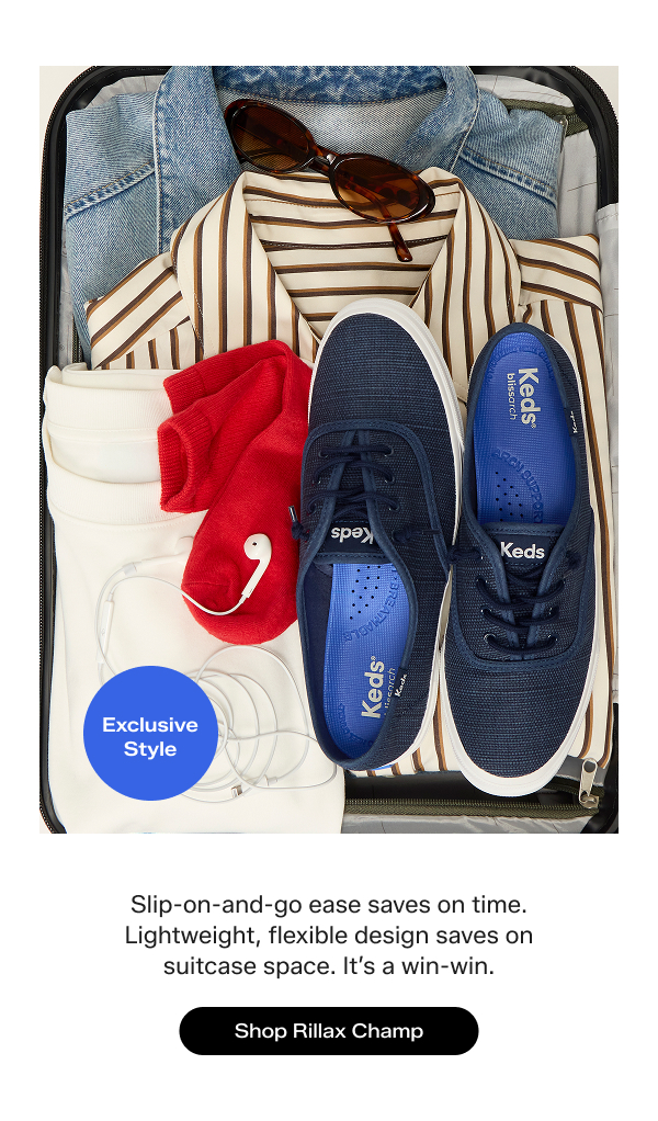 A suitcase filled with folded clothing and accessories, including a denim jacket, cream-and-brown striped shirt, a white T-shirt, earbuds, red socks, and the exclusive Rillax Champ Chalky Canvas Slip-On in navy. The text says Slip-on-and-go ease saves on time. Lightweight, flexible design saves on suitcase space. It’s a win-win. Shop the Rillax Champ.