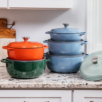 Colorful enameled Dutch ovens stacked on a kitchen counter.