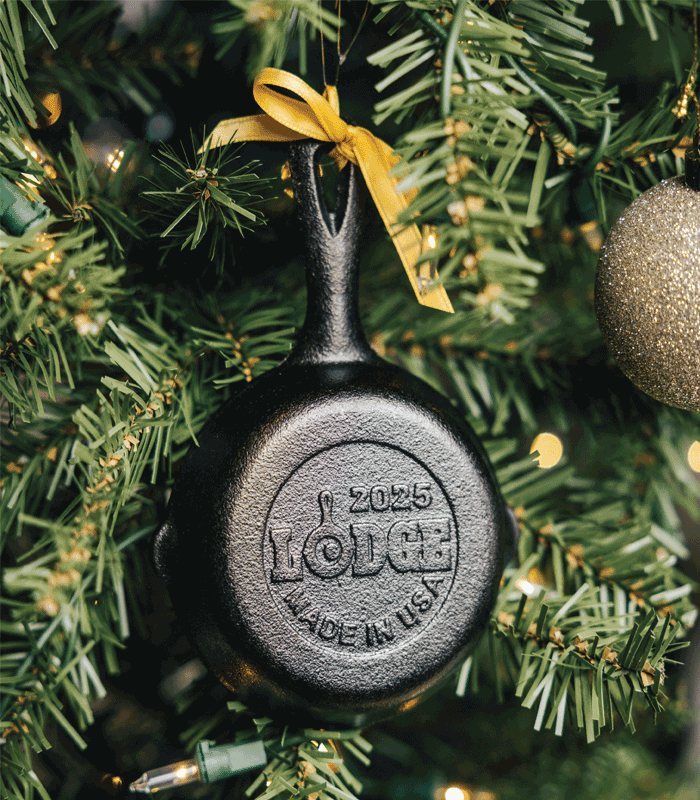 Animated GIF of a 2025 Lodge cast iron skillet ornament with a yellow bow hanging on a decorated Christmas tree.