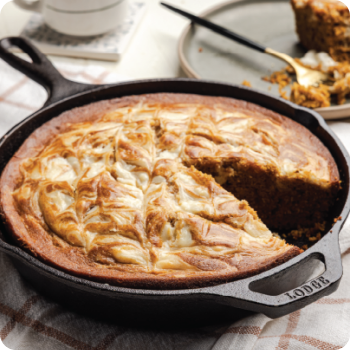 Cast iron skillet with a sliced marbled cake on a kitchen counter