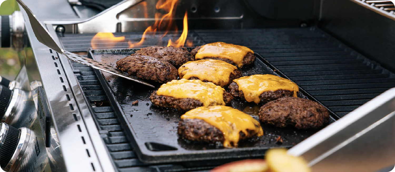 Cheeseburgers sizzling on an outdoor grill