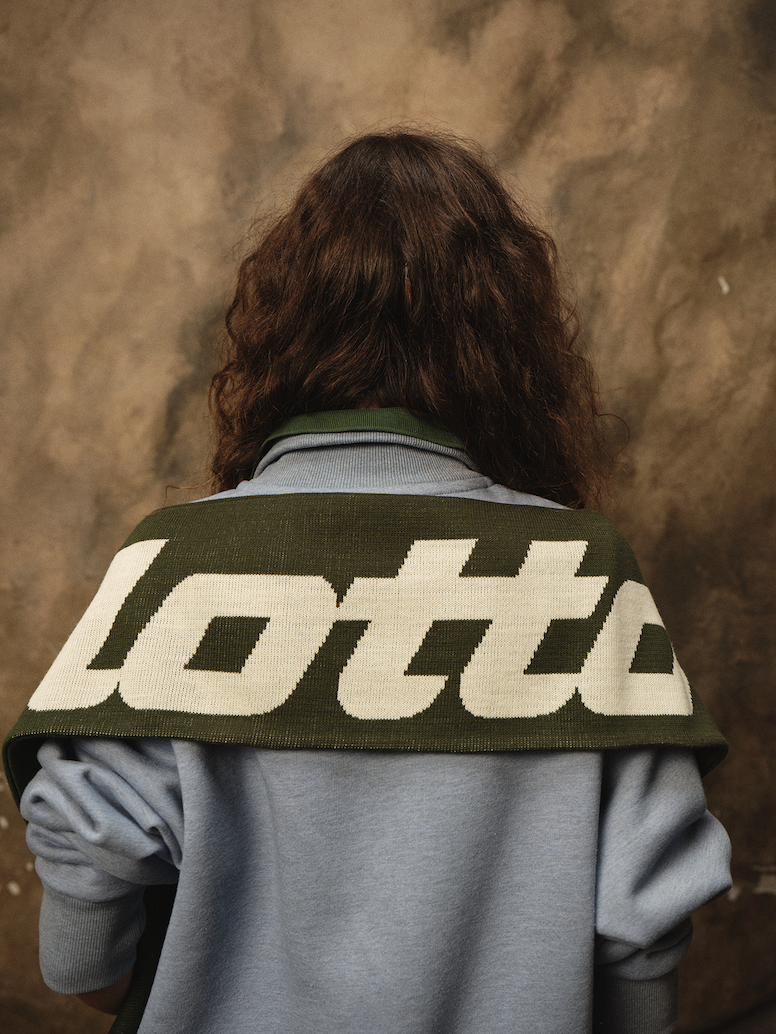 Woman wearing scarf around shoulder that says lotto
