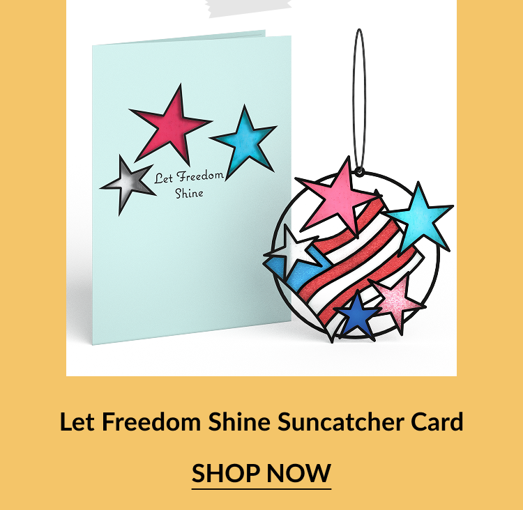 Light blue greeting card with red, blue, and silver stars and the phrase Let Freedom Shine, shown next to a matching circular suncatcher ornament with red and white stripes and colorful stars. Call-to-action below reads Let Freedom Shine Suncatcher Card – Shop Now.