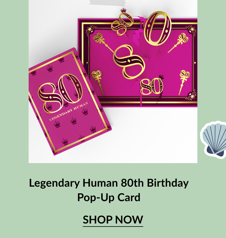 Bright pink and gold pop-up card with the number 80 and crown icons. The front reads Legendary Human. Inside features a 3D pop-up of golden 80s and decorative keys. Call-to-action below reads Legendary Human 80th Birthday Pop-Up Card – Shop Now.
