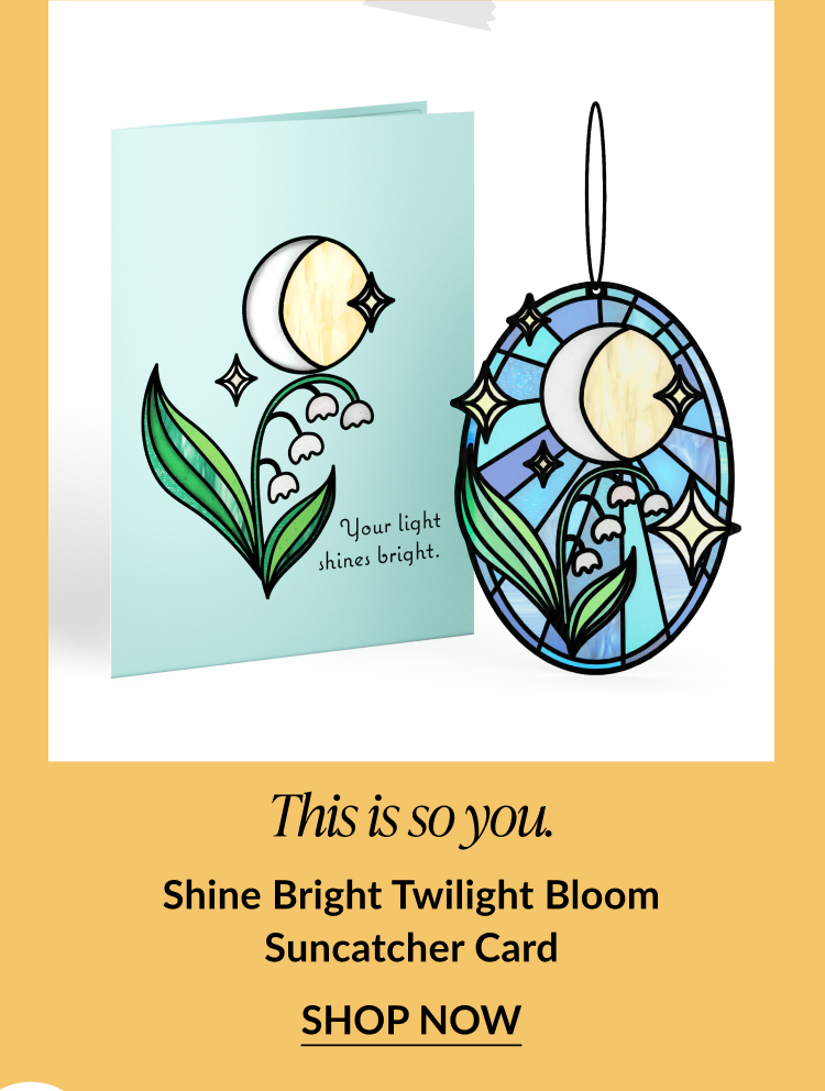 Card with moon and lily-of-the-valley flowers next to a suncatcher with a moon and stars design. Card reads: 'Your light shines bright.' Text below says: 'This is so you. Shine Bright Twilight Bloom Suncatcher Card.' Button reads 'Shop Now.