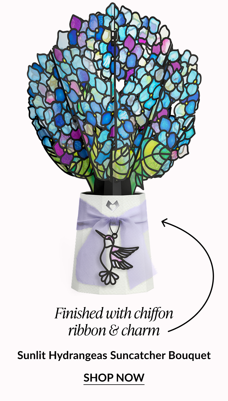 Blue and purple stained-glass hydrangea bouquet with a chiffon ribbon and hummingbird charm.