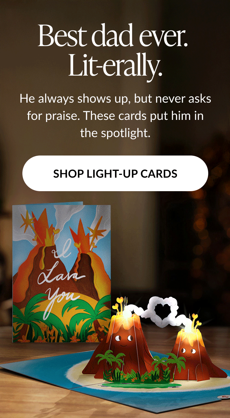 Animated image of a Father's Day card featuring two smiling volcanoes with glowing lava and a heart-shaped smoke cloud. Text reads: ''Best dad ever. Lit-erally. He always shows up, but never asks for praise. These cards put him in the spotlight.'' Button text: ''SHOP LIGHT-UP CARDS''.