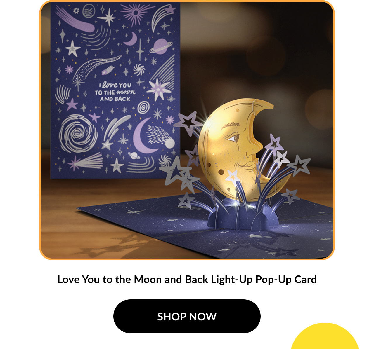 Image of a pop-up card showing a crescent moon with lit-up stars and a deep blue sky. Card cover reads: ''I love you to the moon and back.'' Product name: ''Love You to the Moon and Back Light-Up Pop-Up Card.'' Button text: ''SHOP NOW''.