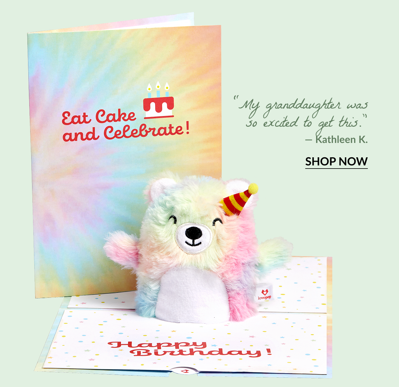 'Eat Cake and Celebrate' Birthday Plushpop Card with a rainbow-colored plush bear wearing a party hat. Quote: My granddaughter was so excited to get this. — Kathleen K.