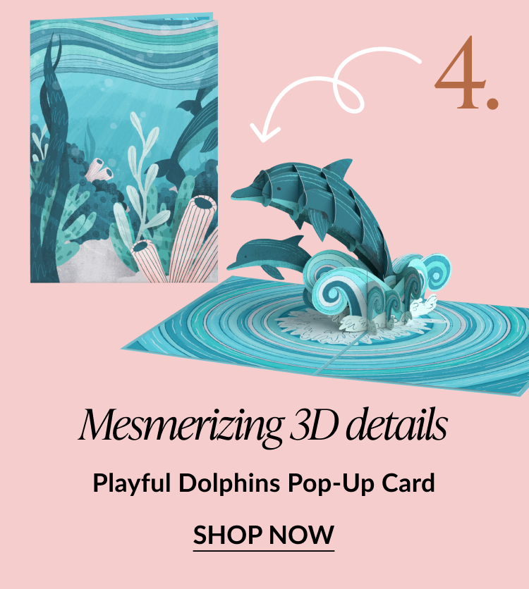 Pop-up card with jumping dolphins splashing through ocean waves. Text reads: Mesmerizing 3D details. Playful Dolphins Pop-Up Card. SHOP NOW.