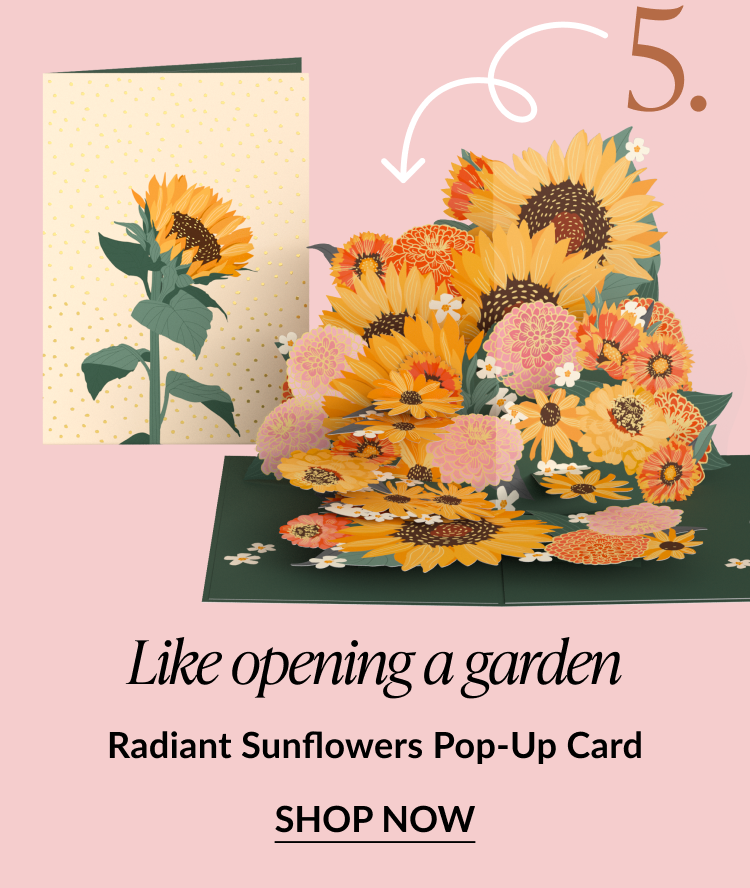 Pop-up card bursting with sunflowers, zinnias, and white flowers. Text reads: Like opening a garden. Radiant Sunflowers Pop-Up Card. SHOP NOW.