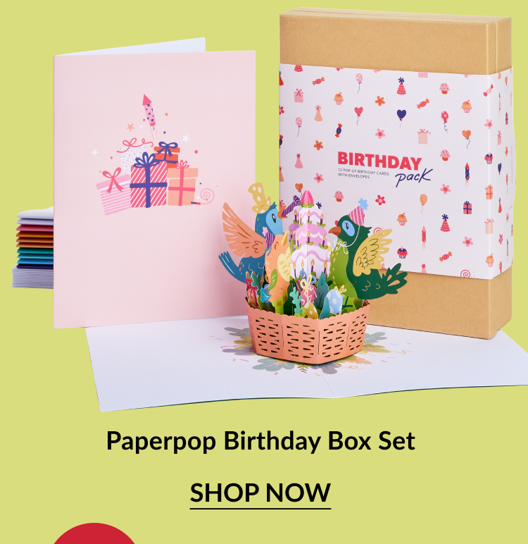 Colorful birthday-themed card set with pastel pink front card and vibrant 3D pop-up basket filled with birds and gifts. Box labeled ''BIRTHDAY pack'' with cheerful party icons.