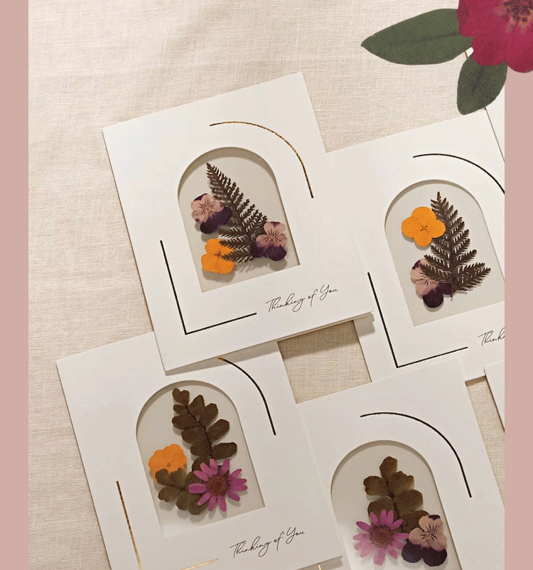 Hand opening the Petal Pressed Notecards box to reveal floral notecards inside.