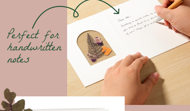 Person writing inside a Petal Pressed notecard featuring lifelike floral details. Perfect for handwritten notes.
