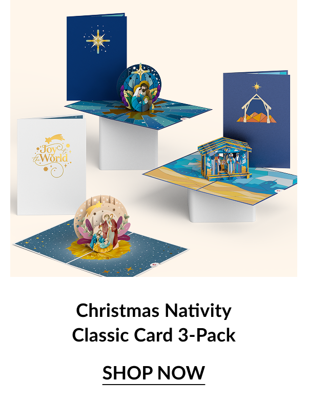 Flat lay of three classic pop-up nativity Christmas cards featuring joyful religious scenes and Joy to the World text.