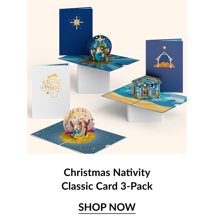 Flat lay of three classic pop-up nativity Christmas cards featuring joyful religious scenes and Joy to the World text.