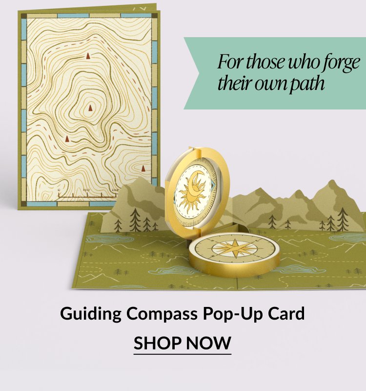 Pop-up card of a compass with a topographic map.