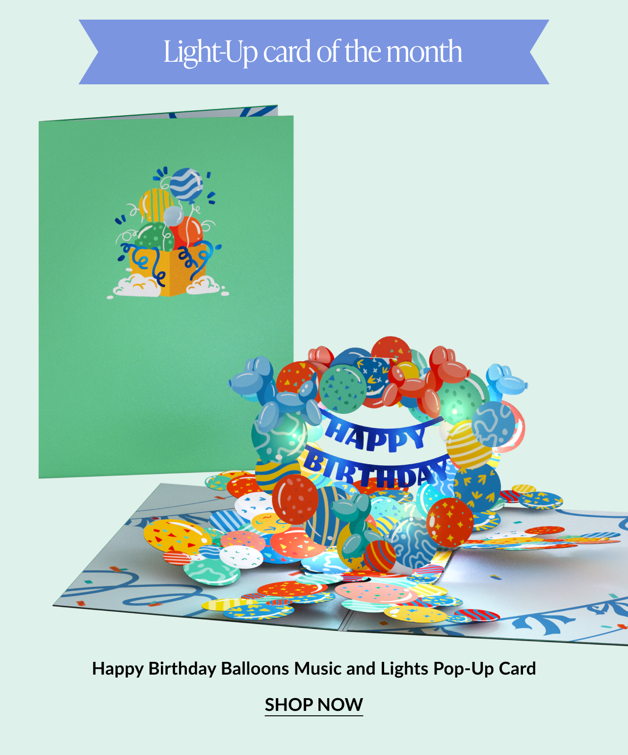 Light-up pop-up birthday card with colorful balloons and a “Happy Birthday” banner. Button: “Shop Now”