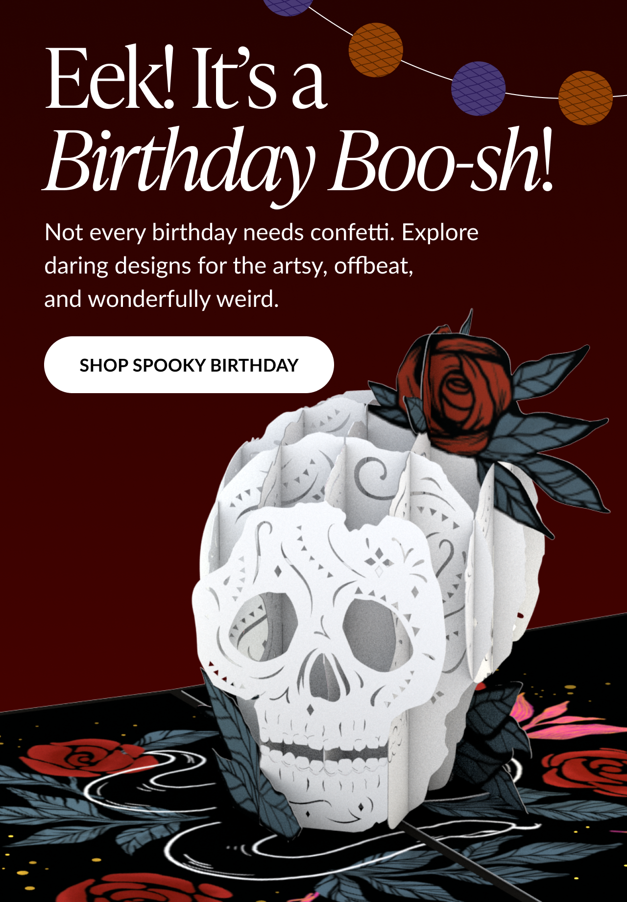 Pop-up birthday card shaped like a white sugar skull with a red rose, set against a dark red background with string lights