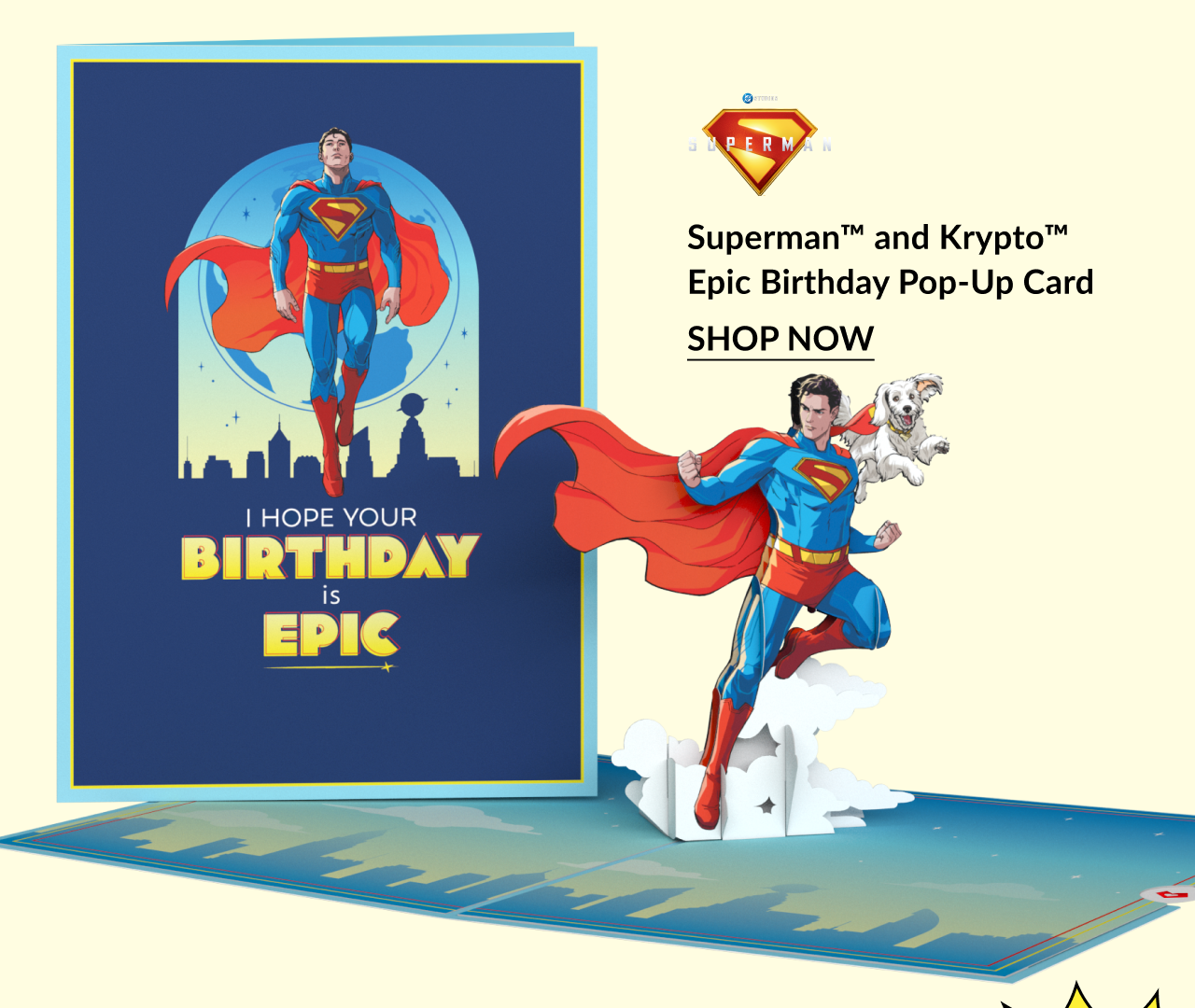 Superman and Krypto Epic Birthday Pop-Up Card with Superman and Krypto flying, accompanied by the message “I hope your birthday is epic” and a “Pow!” text graphic, with “Shop Now” button.