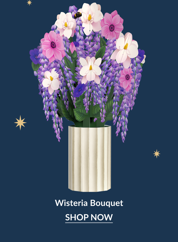 Wisteria Bouquet paper flowers in a cream vase with purple and pink blooms