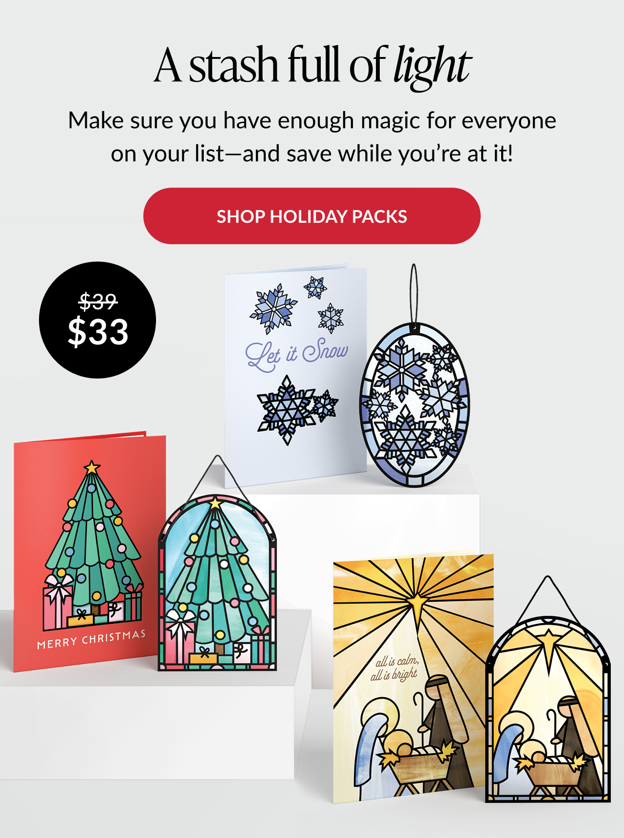Holiday card set with snowflakes, tree, and nativity suncatcher designs, plus red button reading “Shop holiday packs”