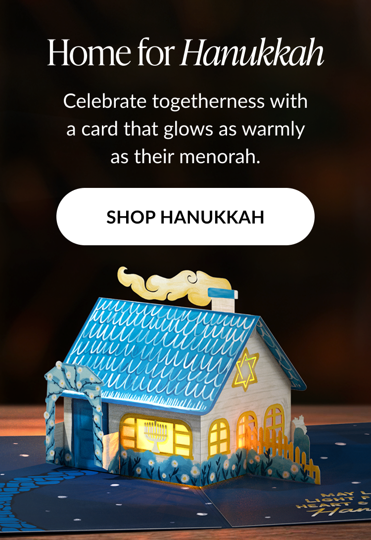 Home for Hanukkah card with glowing blue house featuring menorah and Star of David and shop Hanukkah button