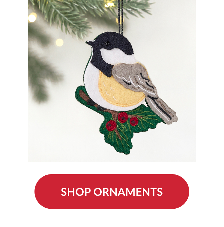 Felt bird ornament perched on holly branch hanging from tree with red button reading shop ornaments