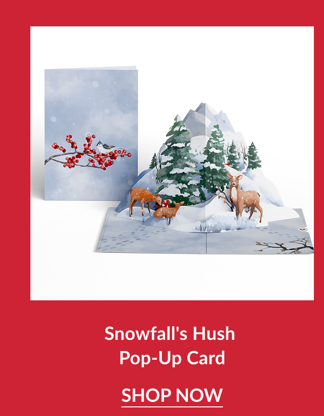 Snowfall’s Hush Pop-Up Card featuring snowy mountain scene with deer and evergreen trees beside a card showing red berries on a winter branch with shop now button