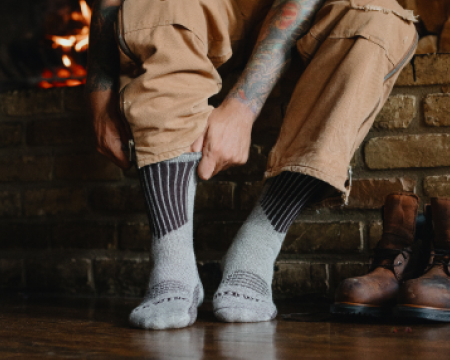 Man putting on high rise Red Wing socks