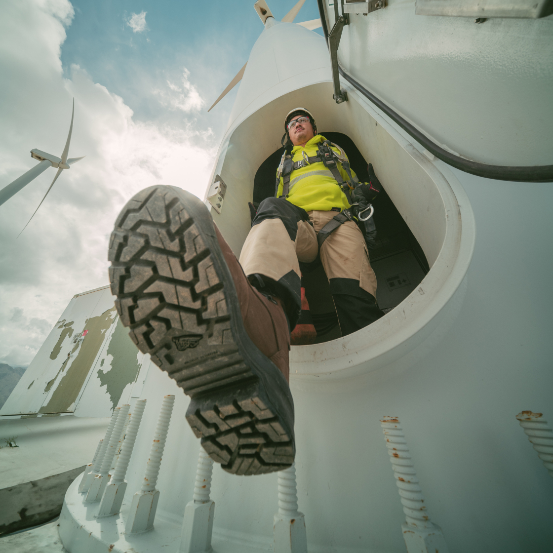 Close up of the bottom of a Red Wing boot while the worker steps out of a windmill
