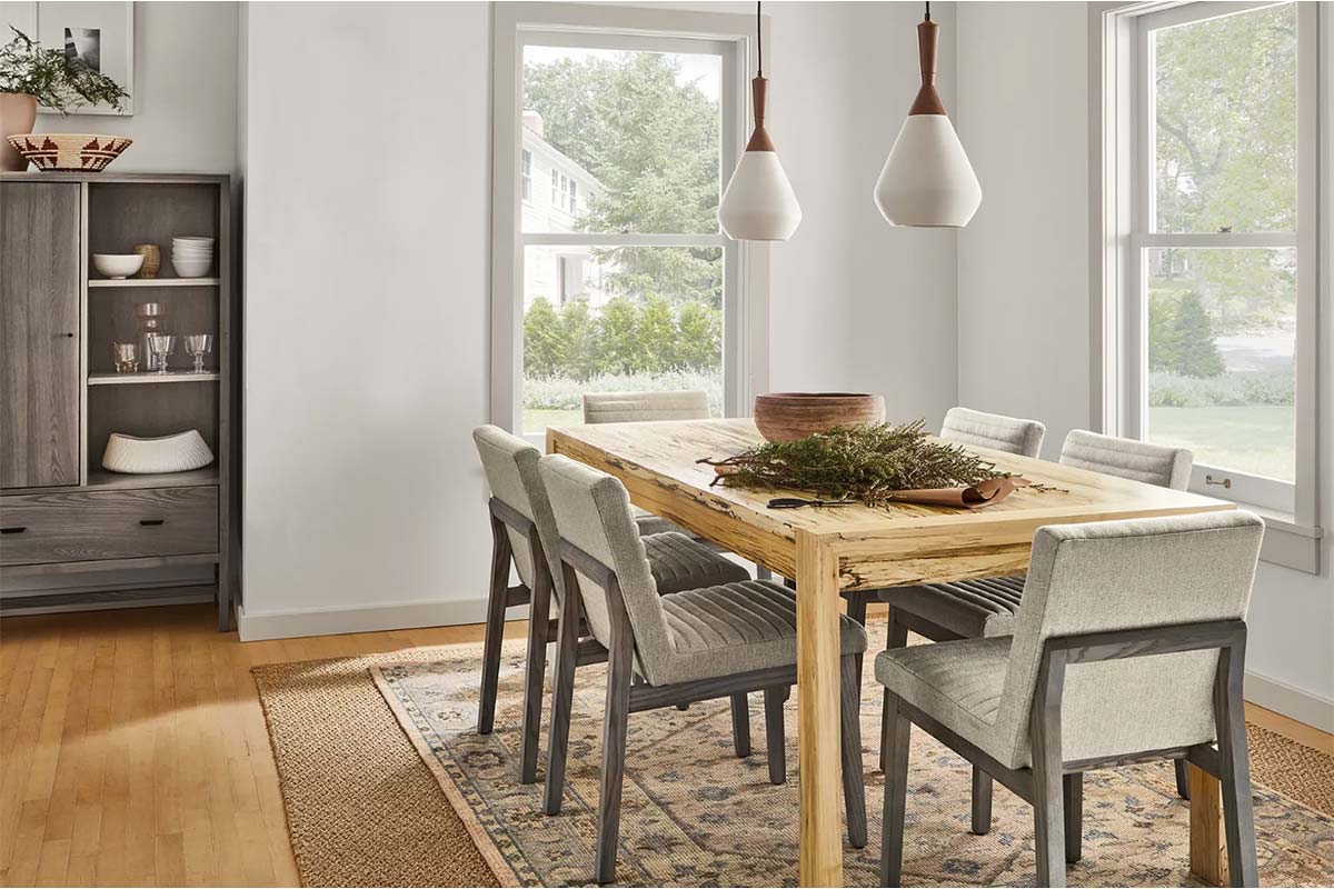 Walsh dining table with six upholstered chairs and pendant lighting above a layered rug.
