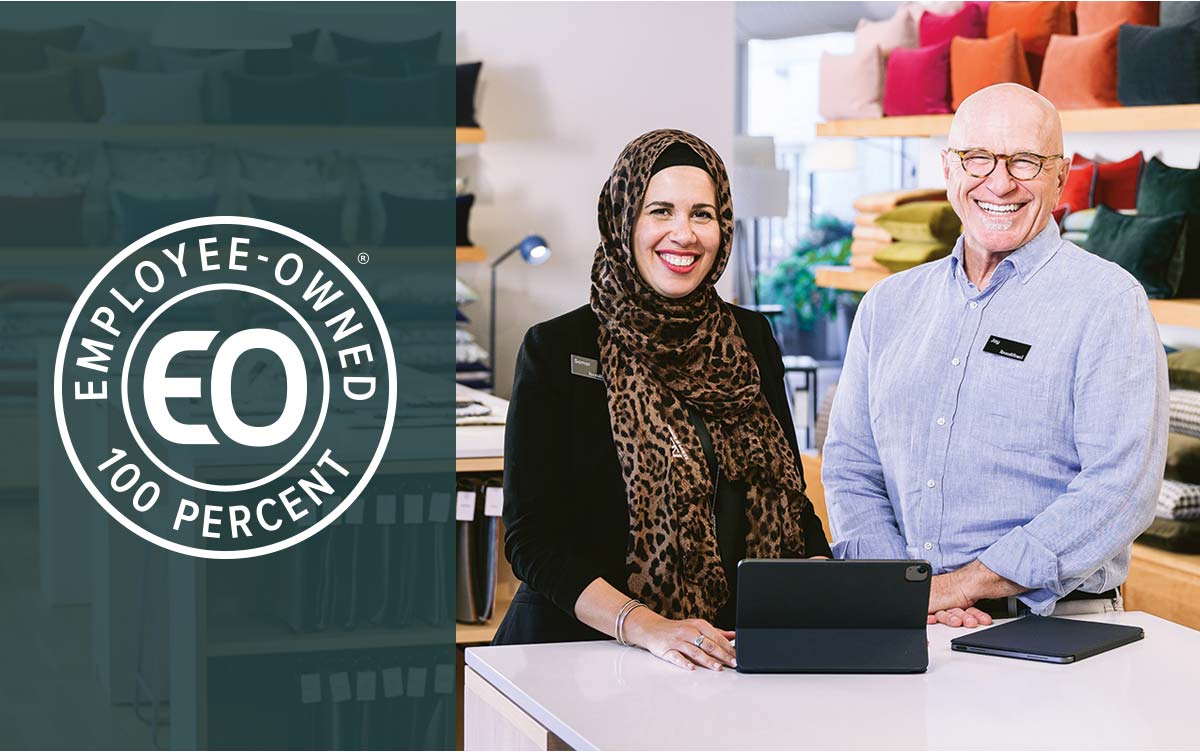 Store team members at the counter with the EO graphic highlighting employee ownership.
