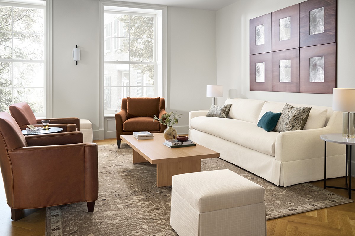 Living room with Sybil skirted sofa, two Savoy leather chairs, a Sybil chair, Corbett table, and Esther ottoman.