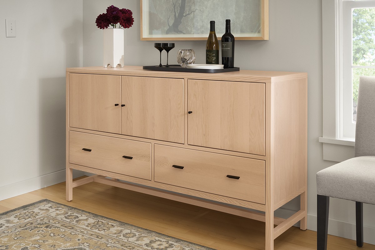 Wooden Berkeley storage console with drawers and top-door compartments, styled with drinks tray and artwork above.
