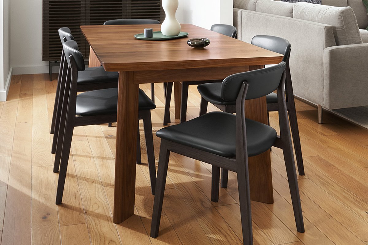 Rectangular Colby dining table in walnut paired with six Errol chairs in black leather and dark-stained wood frames.