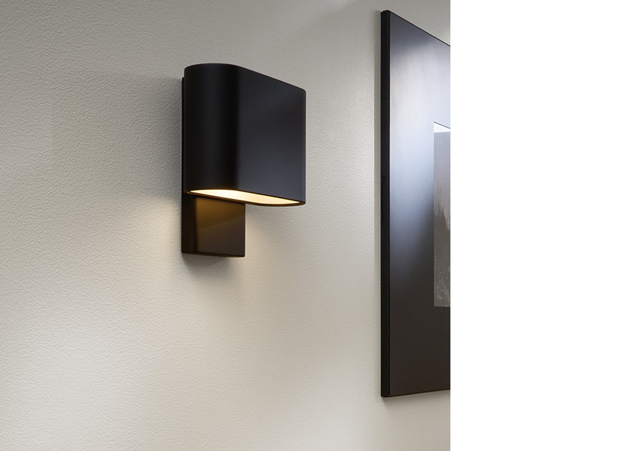 Kalli sconce in graphite mounted near black-edged frame.