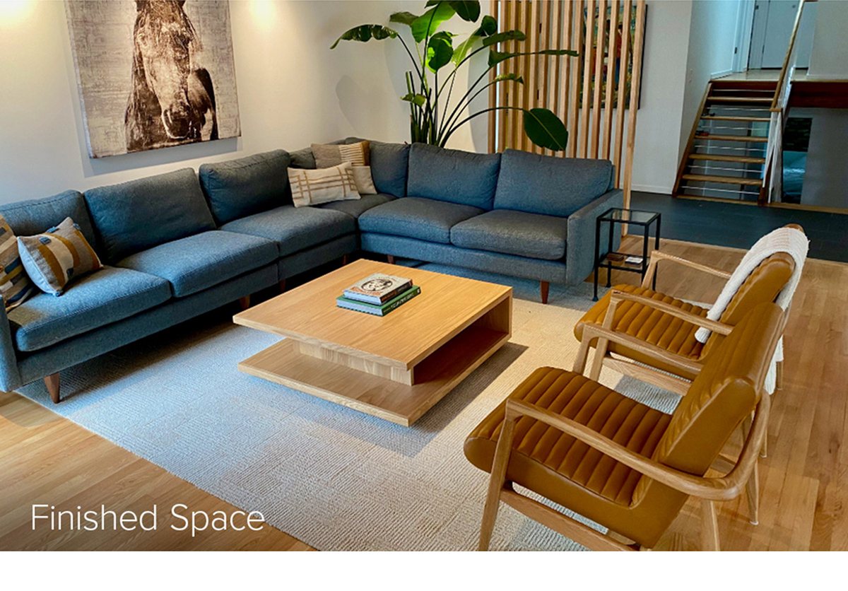 Finished space showing green sectional and chairs around light wood coffee table, with books and decorative pillows.