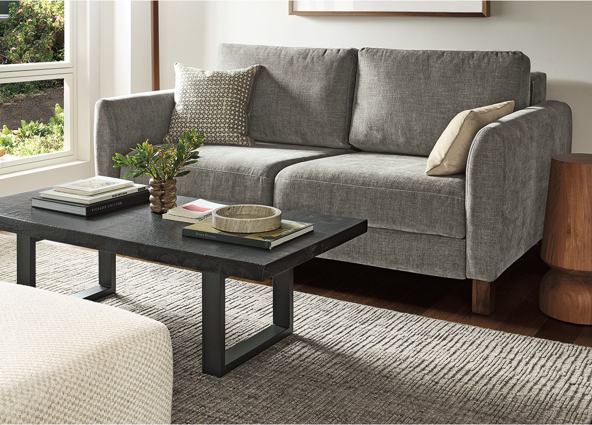 Natalia sleeper sofa extends smoothly into a bed with inset mattress, styled with neutral pillows and side table.