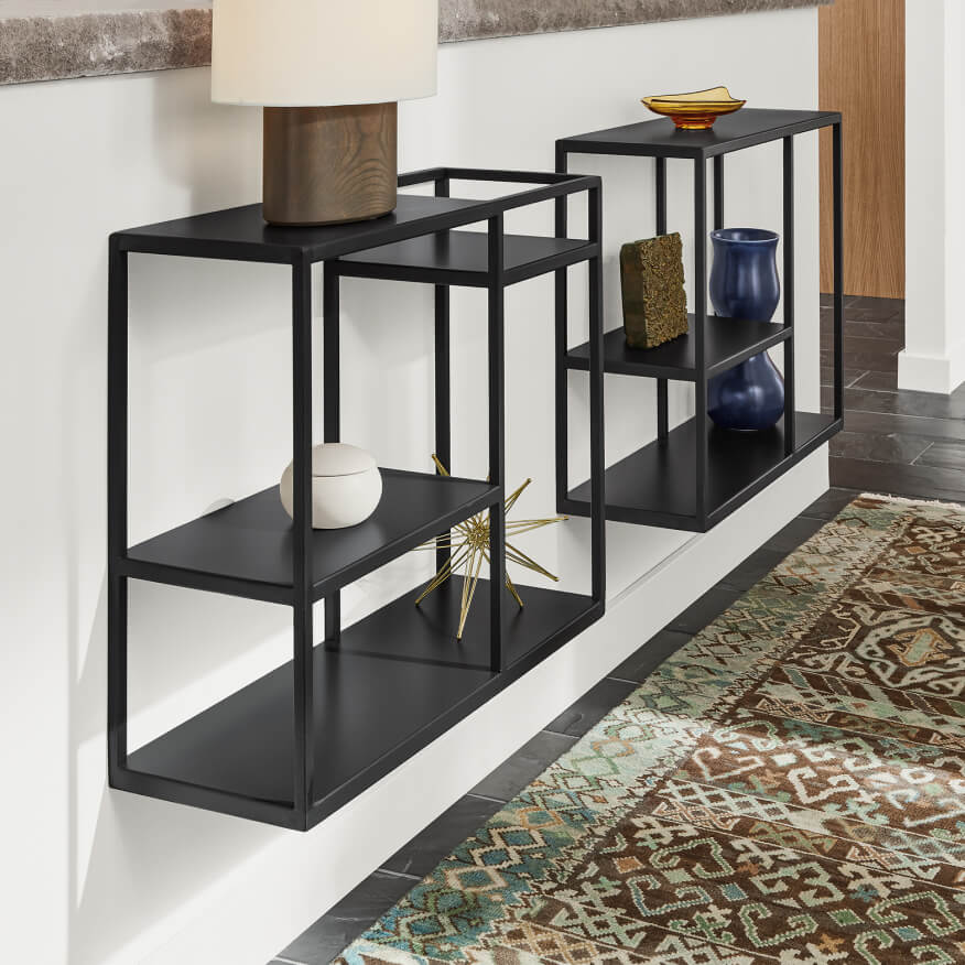 Foshay shelves with black frame and open storage compartments styled with decor pieces along a wall.