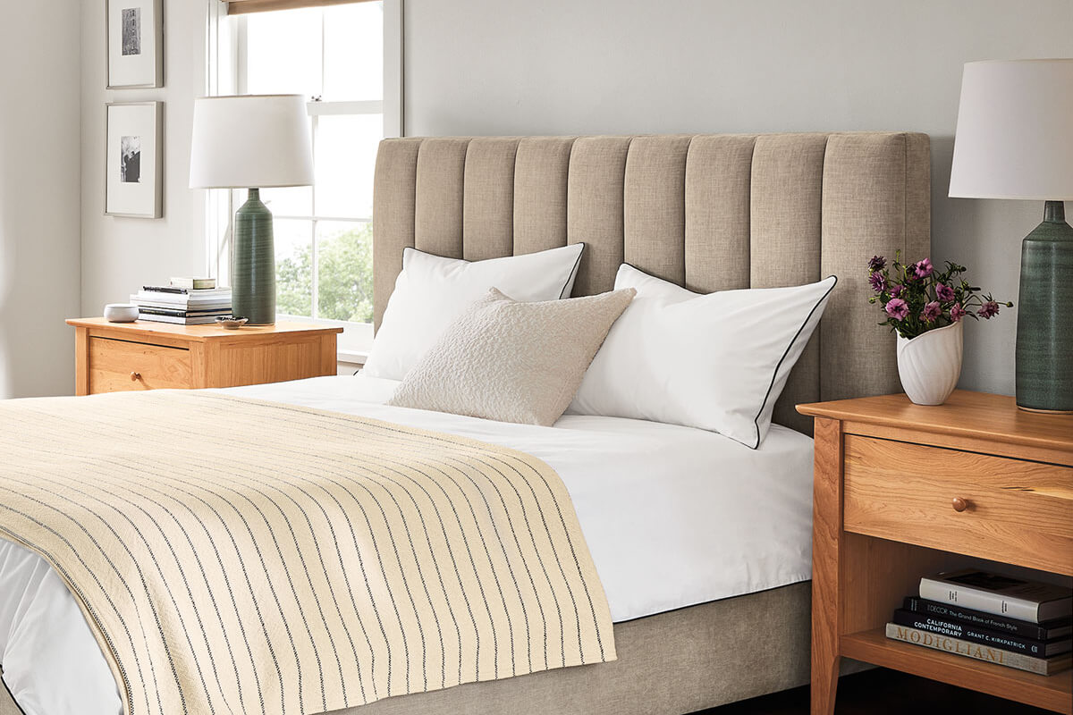 Hartley storage bed with upholstered headboard and white bedding paired with Danbury nightstands and lamps.