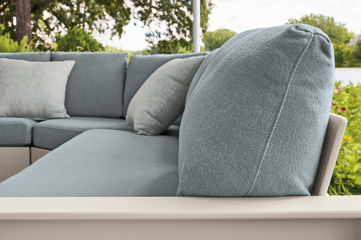 Close-up of Rayo sectional with light blue cushions and white frame, highlighting the seat and back.