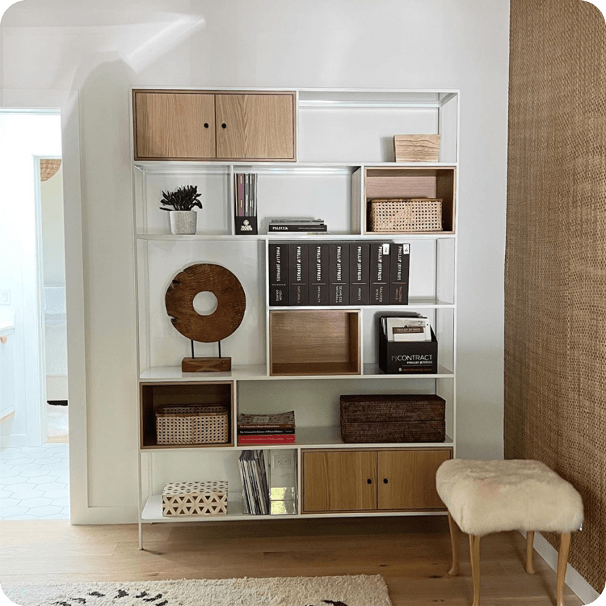 White Foshay bookcase with wood doors and shelves holding books, baskets and decor.