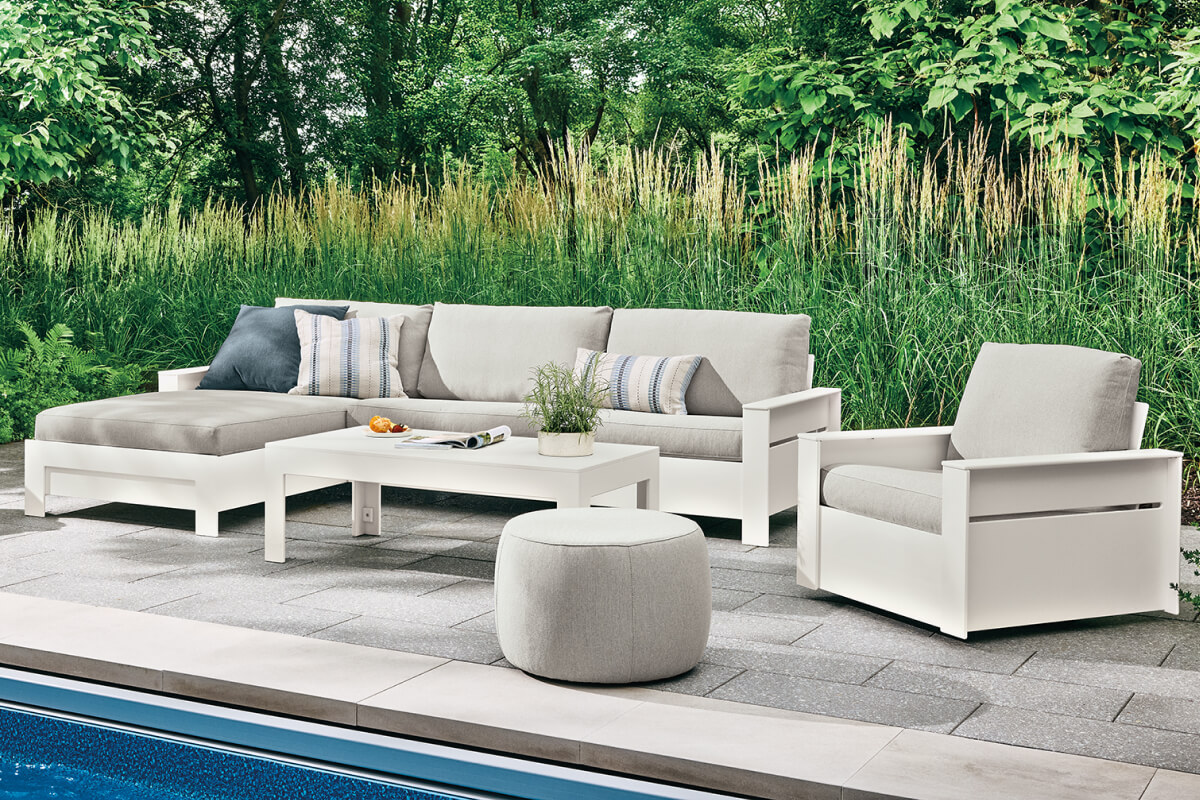 Rayo sectional with chaise and chair arranged around a table on a poolside patio.
