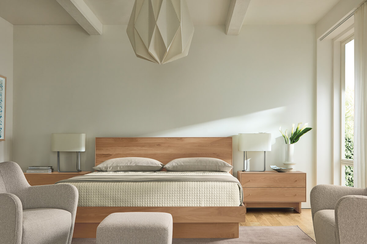 Hudson bed in natural wood paired with Duo table lamps, matching nightstands and upholstered accent chairs.
