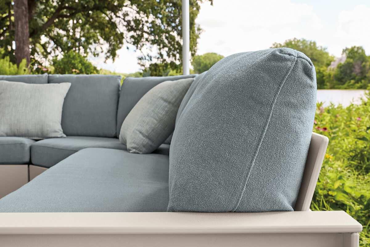 Close-up of a Rayo sectional with light blue cushions and modular seating overlooking the water.