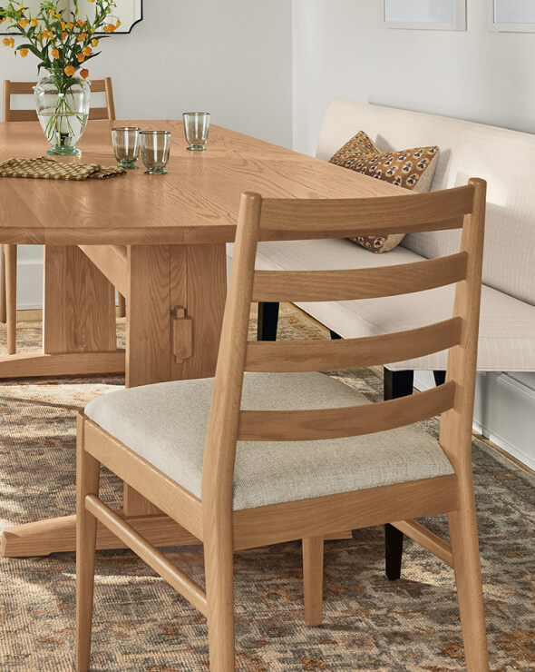 Natural wood Salem table with matching chairs and bench seating on a patterned area rug.